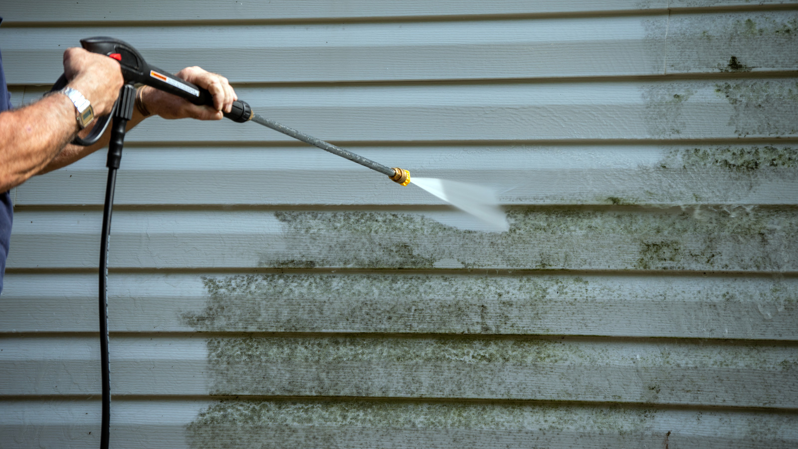 An,Unidentified,Man,Uses,A,Power,Washer,To,Clean,Mold
